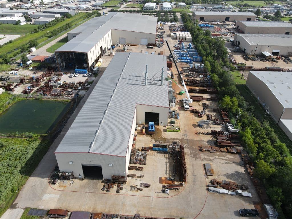 Aerial view of a large industrial facility with storage and equipment in a commercial area.